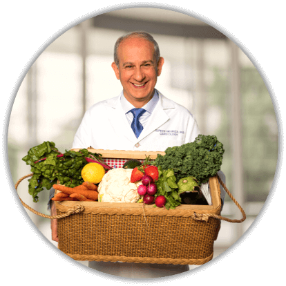 Dr. Stephen Devries, smiling and holding a colorful basket of vegetables