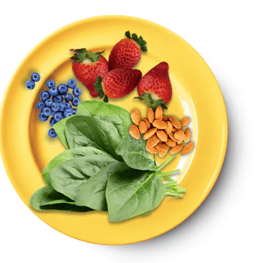 Plate full of blueberries, strawberries, spinach, and almonds